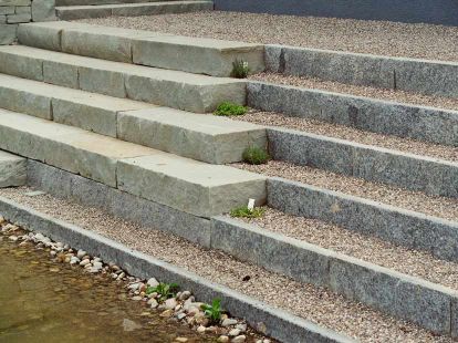 Eine Treppenanlage aus Sandstein und Granit grenzt direkt an den Gartenteich